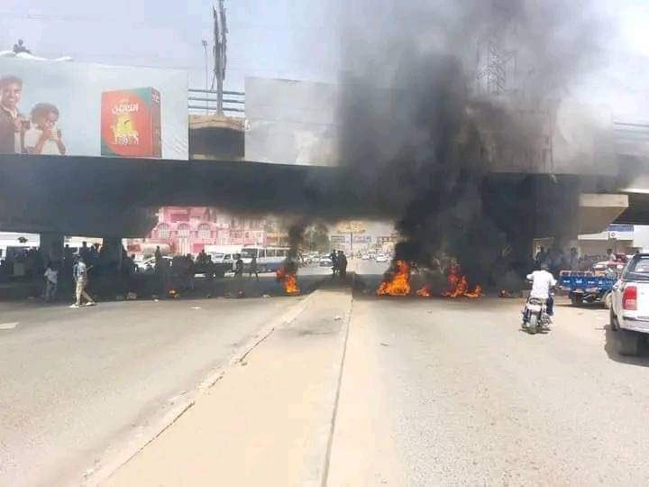 عاجل.. مقتل متظاهر بطلق ناري ومحتجون يعترضون البرهان ويرفعون لافتات صادمة(صور)