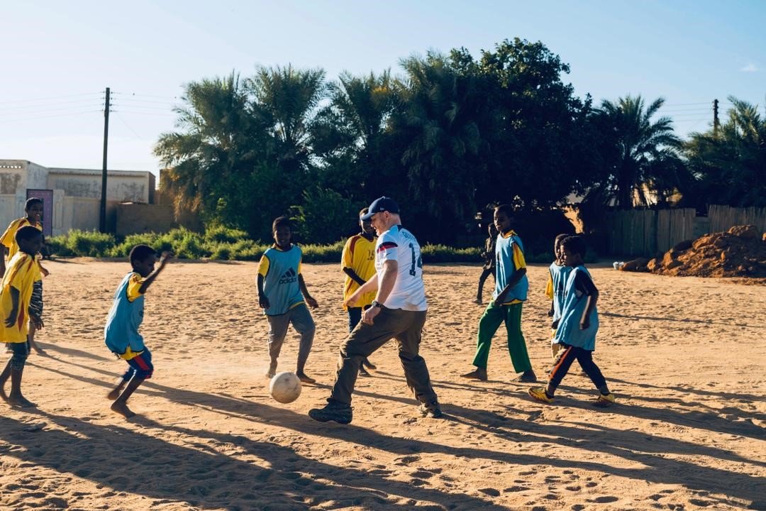 بالصورة.. السفير الأمريكي يلعب مباراة مع أشبال منطقة في السودان